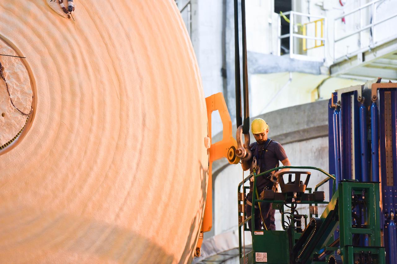 The Space Launch System (SLS) rocket’s liquid oxygen tank structural test article was manufactured and stacked in June 2019 at NASA’s Michoud Assembly Facility in New Orleans. To construct the test article, Boeing technicians at Michoud moved the liquid oxygen tank to the Vertical Assemby Building stacking and integration area. Here, they added simulators to mimic the two structures that connect to the tank, the intertank and the forward skirt.  This structural hardware for the SLS core stage for America’s new deep space rocket is structurally identical to the flight version of the tank. It will be shipped on the Pegasus barge to NASA’s Marshall Space Flight Center in Hunstville, Alabama, where it will undergo a series of tests that simulate the stresses and loads of liftoff and flight. These tests will help ensure designs are adequate for successful SLS missions to the Moon and beyond. The flight liquid oxygen tank along with the liquid hydrogen tank supplies more than 500,000 gallons of propellant to the core stages four RS-25 engines, which produce 2 million pounds of thrust to help send the SLS rocket to space.